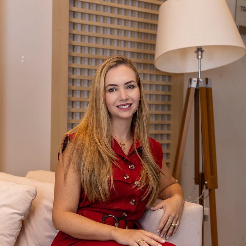 Dra. Gabriela Dourado sentada na recepção da clínica
